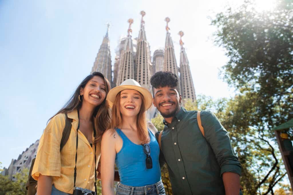 Jóvenes migrantes en España disfrutando frente a la Sagrada Familia.