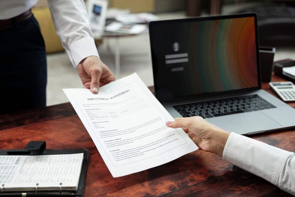 Como buscar trabajo en España: entrega de contrato de empleo en una oficina