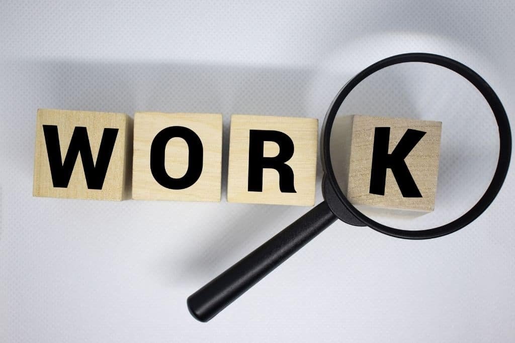 Como buscar trabajo en España: letras “WORK” con lupa simbolizando búsqueda de empleo